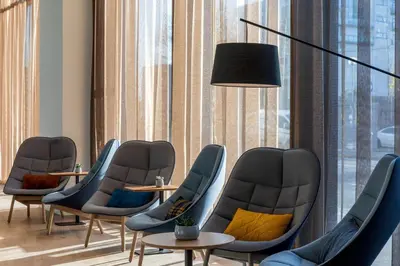 a waiting room with chairs and tables and a lamp at Courtyard by Marriott Glasgow SEC in Glasgow