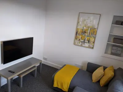 a living room with a couch and a flat screen tv at Glenclova - No 5 Bellyeoman, bright two bedroom apartment in Fife