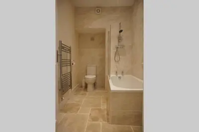a bathroom with a tub and a toilet and a sink at 17 William Street in Helensburgh
