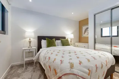 a bedroom with a large bed with green pillows at SECC Hydro Clyde View Apartment in Glasgow