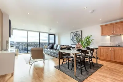 a kitchen and living room with a table and a couch at SECC Hydro Clyde View Apartment in Glasgow