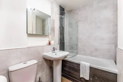 a bathroom with a sink and a toilet and a bath tub at Fresh, modern West End apartment beside Hydro in Glasgow