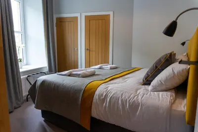 a bedroom with a bed with two towels on it at Airds Apartments in Oban
