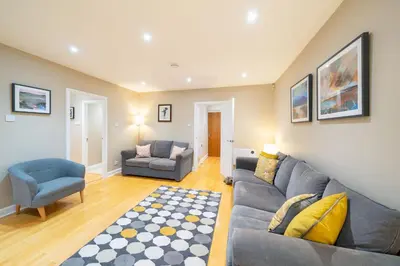 a living room with a couch and a chair at Strathallan - Luxury 3 Bedroom Apartment, Gleneagles, Auchterarder in Auchterarder