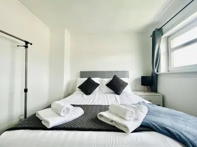 a bedroom with a bed with towels on it at Central Hamilton House in Hamilton