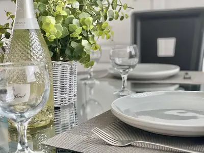 a table with a bottle of wine and plates and glasses at Central Hamilton House in Hamilton