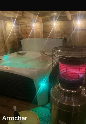 a person in a hot tub with lights at MacLeen Cottage in Arrochar