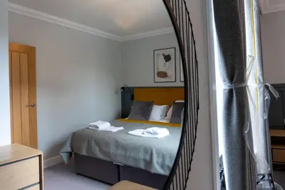 a bedroom with a bed in a mirror at Argyle Square Apartment in Oban
