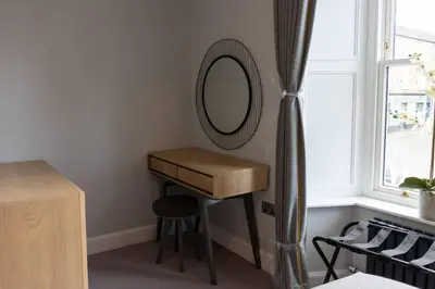 a dressing table with a mirror next to a window at Argyle Square Apartment in Oban