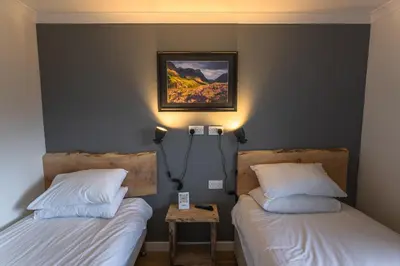 a bedroom with two beds and a picture on the wall at Roam West in Fort William