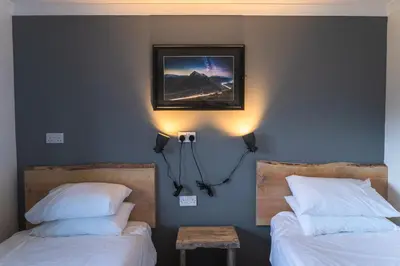 a bedroom with two beds and a picture on the wall at Roam West in Fort William