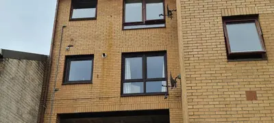 a brick building with windows on the side of it at Espedair Apartment in Paisley