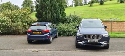 two cars parked next to each other in a parking lot at Espedair Apartment in Paisley
