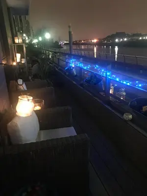 a balcony at night with blue lights on it at Glasgow Harbour Clyde Waterfront Apartment in Glasgow