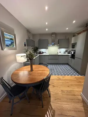 a kitchen with a wooden table and chairs at Glasgow Harbour Clyde Waterfront Apartment in Glasgow