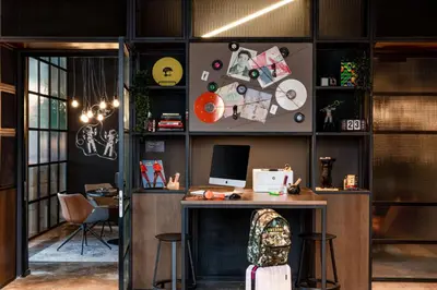 an office with a desk with a computer and stools at Moxy Glasgow SEC in Glasgow