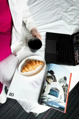 a table with a book and a bowl of food and a laptop at Moxy Glasgow SEC in Glasgow