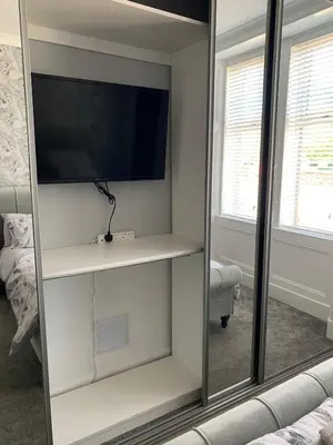 a mirror in a room with a tv and a couch at Woodvale Flat, Renton, Loch Lomond in Renton