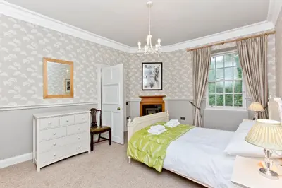 a bedroom with a bed and a dresser and a window at Luxury-3-bedroom Ramsay Garden Apartment next to Edinburgh Castle in Edinburgh