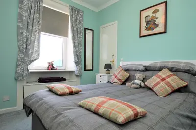 a bedroom with a bed with a teddy bear on it at Arthur's Seat in Innellan