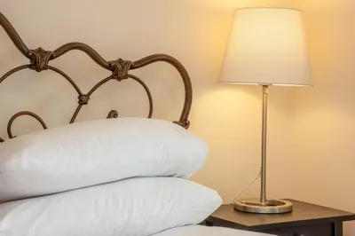 a bed with a pillow and a lamp on a table at Island View in Oban