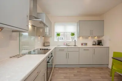 a kitchen with white cabinets and a counter top at Island View in Oban