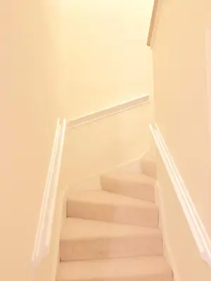 a staircase in a house with white walls at Glasgow City Centre G1 PENTHOUSE with RiverViews - Duplex - 4 Bedrooms, 3 Bathrooms, Kitchen, 1 Living room, 1 Dining room, 2 Terraces, Parking, Top Floor, 2050 sq ft, Merchant City in Glasgow