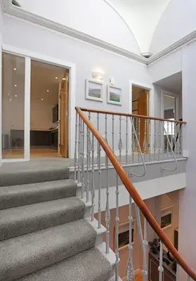 a staircase in a house with white walls and wood floors at The Shandwick Place Residence No 2 in Edinburgh