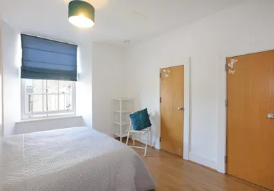 a bedroom with a bed and a window and a chair at The Shandwick Place Residence No 2 in Edinburgh