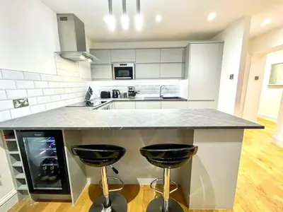 a kitchen with a counter and two stools at Prime Edinburgh New Town. Newly reno'd cosy nest in Edinburgh