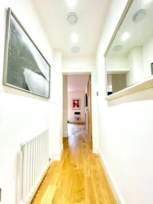a hallway of a home with white walls and wooden floors at Prime Edinburgh New Town. Newly reno'd cosy nest in Edinburgh