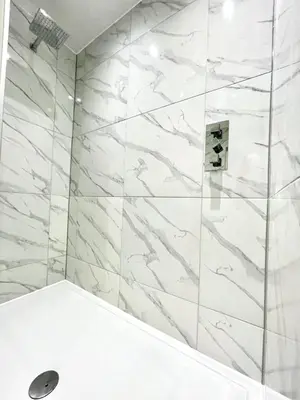 a bathroom with a shower with white marble walls at Prime Edinburgh New Town. Newly reno'd cosy nest in Edinburgh