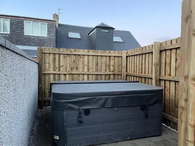 a black trunk sitting in front of a wooden fence at 4 Bed-Sleeps 8- Free Parking-Pets-Hot Tub in Kelty