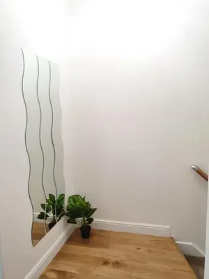 a living room with a mirror on the wall at Glasgow Comfortable and Modern 3 Bedroom Mid Terraced Villa in Glasgow