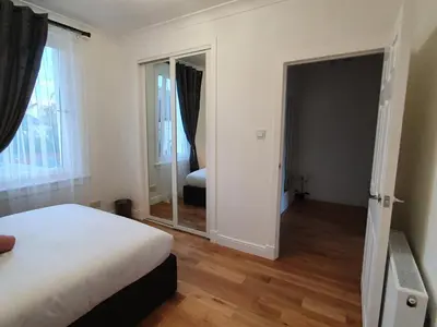 a bedroom with a bed and a mirror at Glasgow Comfortable and Modern 3 Bedroom Mid Terraced Villa in Glasgow