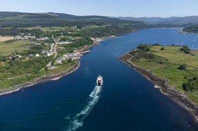 a boat is traveling down a river at Highland Basecamp in Lochaline