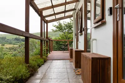 a porch of a house with a wooden walkway at Highland Basecamp in Lochaline