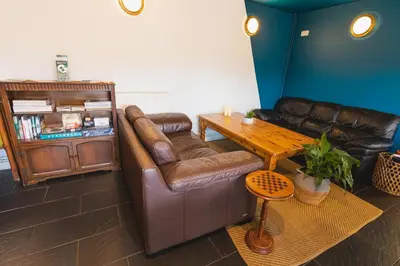 a living room with a leather couch and a table at Highland Basecamp in Lochaline