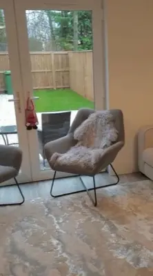 a chair sitting in a living room with a window at Glasgow City Central Executive Triplex House, 3 Bedroom 3 Bathrooms 1 living room Kitchen - Huge Terrace for Master Bedroom - Private E Parking LEZ Congestion Zone Free - Garden - 5 mins drive to City Centre Central Station in Glasgow