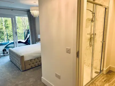 a bedroom with a bed and a glass shower at Glasgow City Central Executive Triplex House, 3 Bedroom 3 Bathrooms 1 living room Kitchen - Huge Terrace for Master Bedroom - Private E Parking LEZ Congestion Zone Free - Garden - 5 mins drive to City Centre Central Station in Glasgow