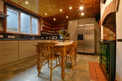 a kitchen with a wooden table and a refrigerator at Cologin in Oban