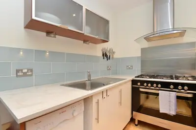 a kitchen with a sink and a stove at Home by The Meadows, close to City Centre in Edinburgh
