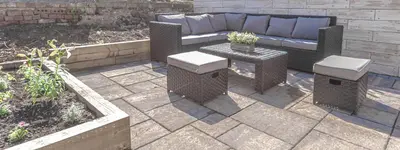 a patio with a couch and a table and some plants at 1 Bed Cottage-Sleeps 2-Parking-Pets-Hot Tub in Kelty