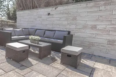 a patio with a couch and a table and chairs at 1 Bed Cottage-Sleeps 2-Parking-Pets-Hot Tub in Kelty