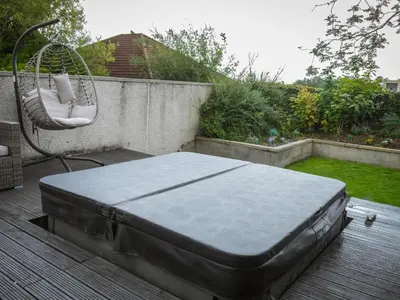 a bed sitting on top of a wooden deck at 1 Bed Cottage-Sleeps 2-Parking-Pets-Hot Tub in Kelty