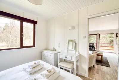 a bedroom with a bed and a desk and a mirror at Portnellan in Crianlarich