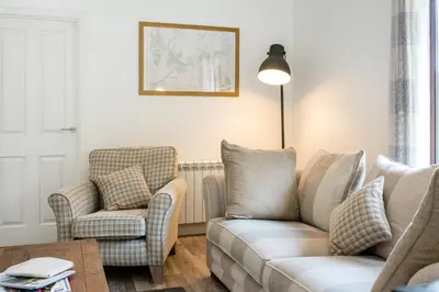 a living room with a couch and two chairs at Portnellan in Crianlarich