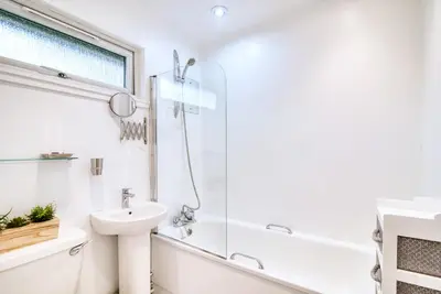a white bathroom with a sink and a shower at Portnellan in Crianlarich