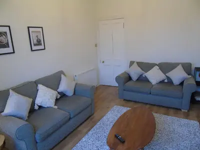 a living room with two couches and a coffee table at Snug - Tearlag Apartment in Helensburgh