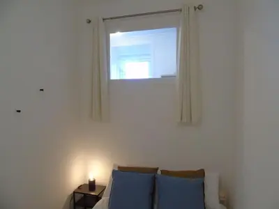 a living room with a couch and a window at Snug - Tearlag Apartment in Helensburgh
